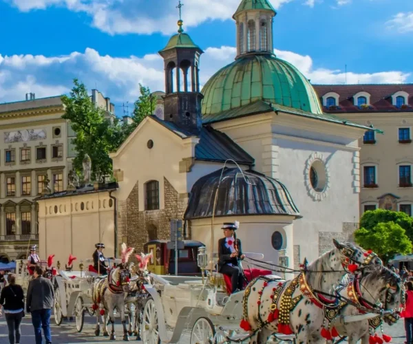 Kraków, kościół św. Wojciecha na płycie Rynku Głównego, a przed nim kolejka dorożek